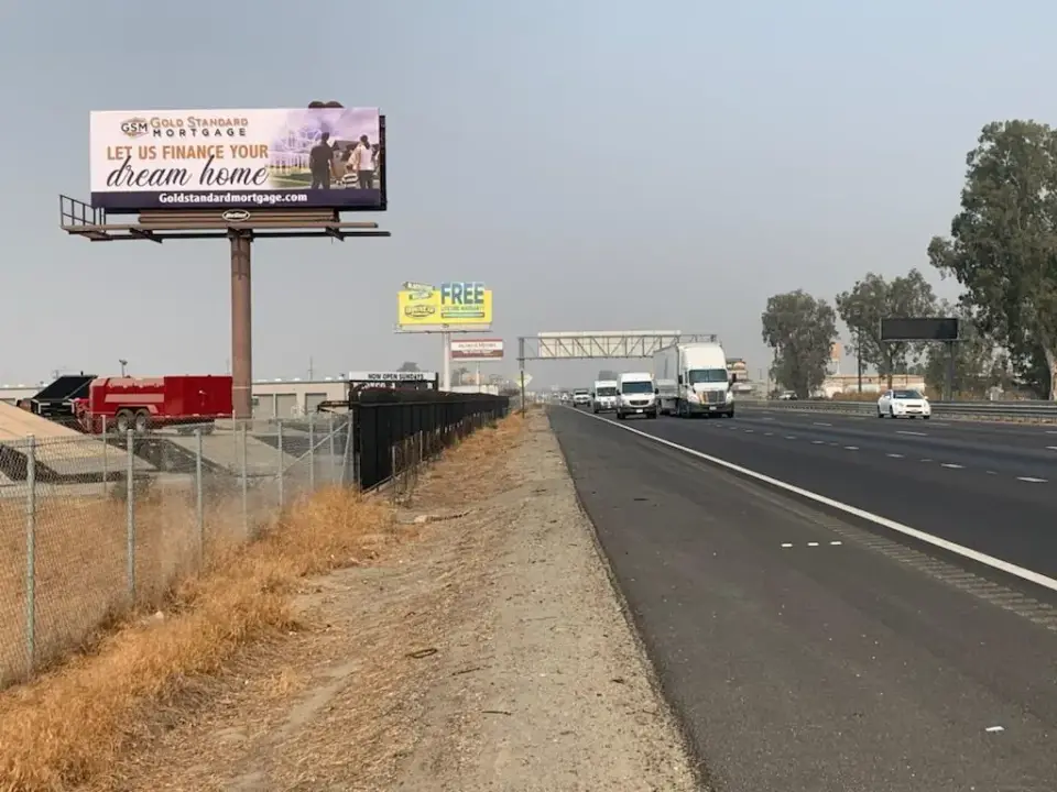 Home-financing billboard beside Highway 99 traffic in Goshen