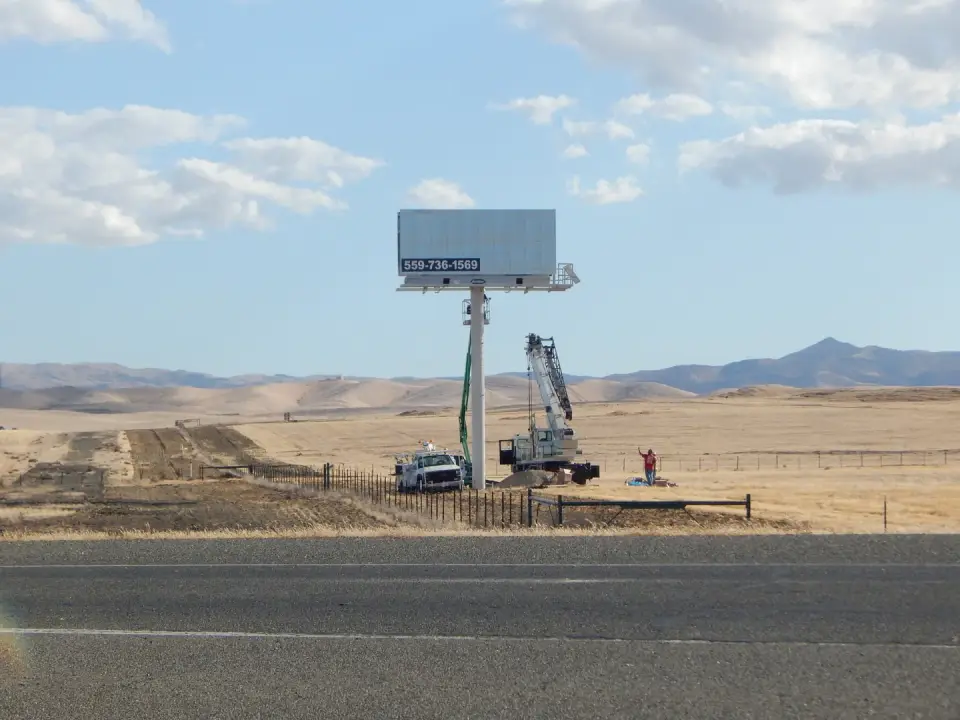 Crane crew erecting a blank billboard near Highways 41 and 33