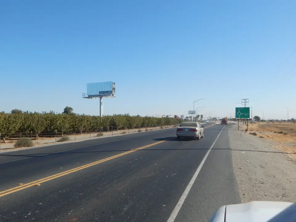 Billboard and traffic along a rural highway near Hanford
