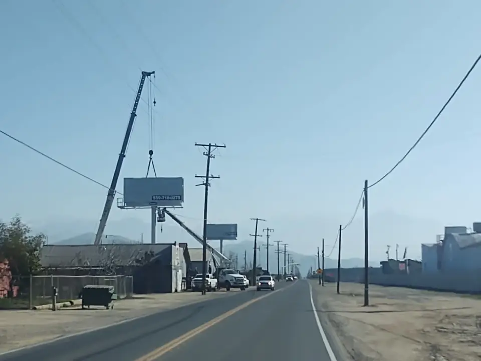 Crane servicing a roadside billboard near Woodlake